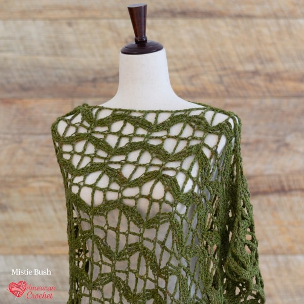Flying Butterflies Poncho crochet pattern — olive green open lace poncho with wing-like drape on dress form, American Crochet bestseller