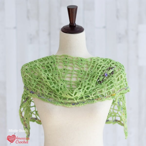 Springtime Violets Wraplet crochet pattern - spring green open mesh shoulder wrap with multicolor speckled trim on dress form, American Crochet