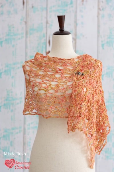 Amber Rose Wrap crochet pattern - open lace mesh wrap in warm peachy coral on dress form, American Crochet