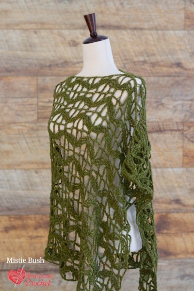 Flying Butterflies Poncho crochet pattern — olive green open lace poncho with wing-like drape on dress form, American Crochet bestseller