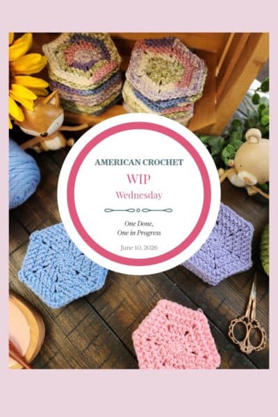 A tall Pinterest image featuring crocheted hexagons in soft blue, lavender, and pink solid colors alongside a stack of variegated spring pastel hexagons on a dark wood surface. A wooden fox figurine, a wooden bear figurine, yellow sunflowers, greenery, ornate scissors, a crochet hook, a skein of blue yarn, and a wood slice dish are styled around the hexagons. A white circle badge in the center reads "American Crochet — WIP Wednesday — One Done, One in Progress — June 10, 2026." A soft pink border frames the image.